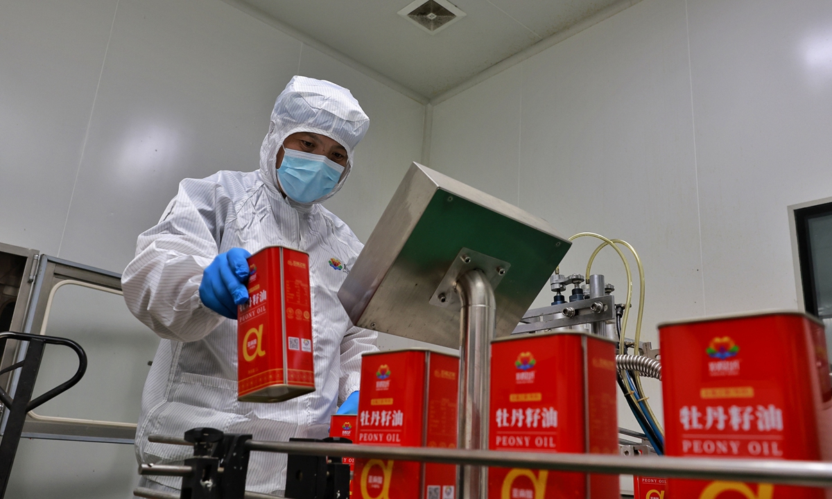 A worker checks peony seed oil at the Heze Guyu Peony Biotechnology Co Ltd on April 19, 2023.