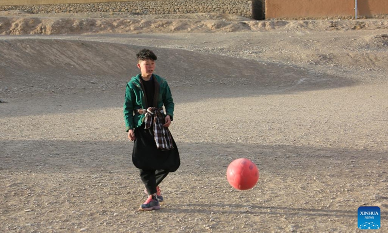 An Afghan boy plays football in front of the Buddha site in Bamyan province, Afghanistan, Feb. 7, 2023. Millions of kids around the world dream of becoming football legend Lionel Messi, but Afghan boy Amir Husain is not one of them. He has never even seen a live game of the Argentinian national football team.(Photo: Xinhua)