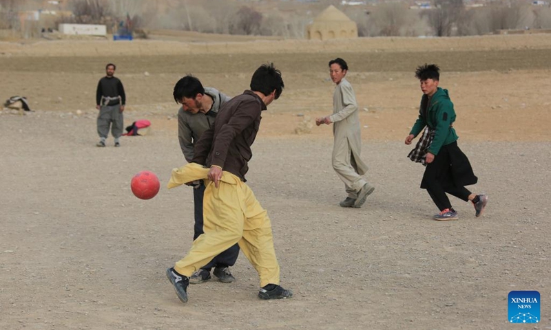 Young people play football in front of the Buddha site in Bamyan province, Afghanistan, Feb. 7, 2023. Millions of kids around the world dream of becoming football legend Lionel Messi, but Afghan boy Amir Husain is not one of them. He has never even seen a live game of the Argentinian national football team.(Photo: Xinhua)