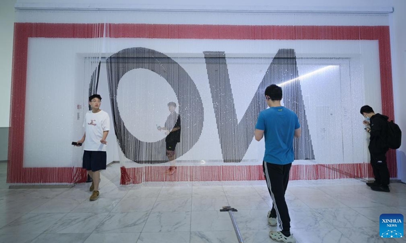 Visitors view a piece of artwork named ON at 2023 China Central Academy of Fine Arts (CAFA) postgraduate works exhibition in Beijing, capital of China, May 9, 2023. Over 3,000 pieces of postgraduate works were displayed in the exhibition, including paintings, sculptures, digital art, etc.(Photo: Xinhua)