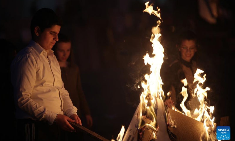 An ultra-Orthodox Jew lights a bonfire to celebrate the Jewish holiday of Lag BaOmer in Ashdod, Israel, on May 8, 2023.(Photo: Xinhua)