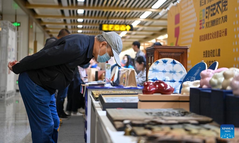 People view a piece of artwork at an exhibition featuring cultural and creative products at Dananmen Station of Taiyuan Subway Line 2, Taiyuan, capital of north China's Shanxi Province, May 9, 2023. More than 200 pieces of artwork were displayed at the exhibition, showcasing this city's history. The exhibition runs until May 12.(Photo: Xinhua)