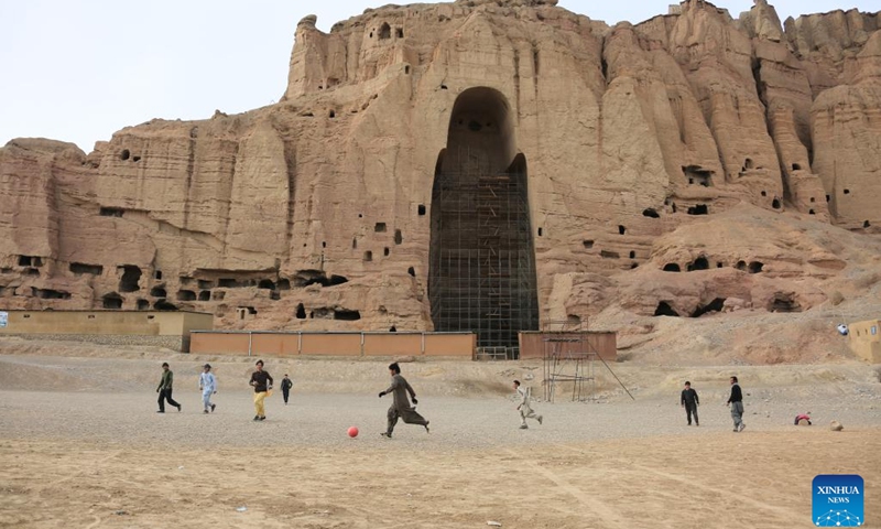Young people play football in front of the Buddha site in Bamyan province, Afghanistan, Feb. 7, 2023. Millions of kids around the world dream of becoming football legend Lionel Messi, but Afghan boy Amir Husain is not one of them. He has never even seen a live game of the Argentinian national football team.(Photo: Xinhua)