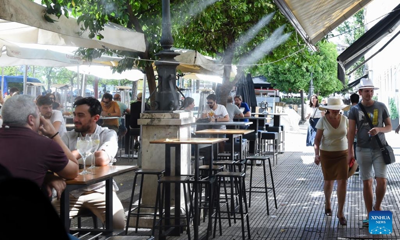 People cool off in a spray of water from a street bar in Sevilla, Spain, May 7, 2023. Spain has been hit by days of heat wave and drought.(Photo: Xinhua)