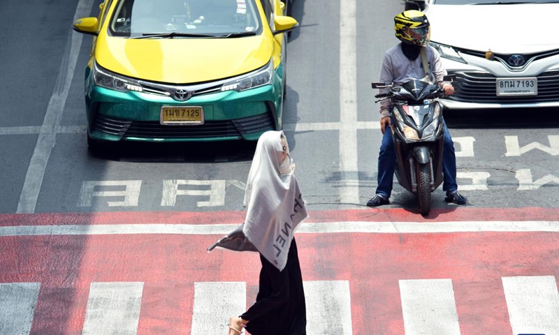 A pedestrian shades herself from sunshine with a scarf in Bangkok, Thailand, May 17, 2023. Thailand is hit by a heat wave, with the highest temperature in Bangkok reaching 41 degrees Celsius recently.(Photo: Xinhua)