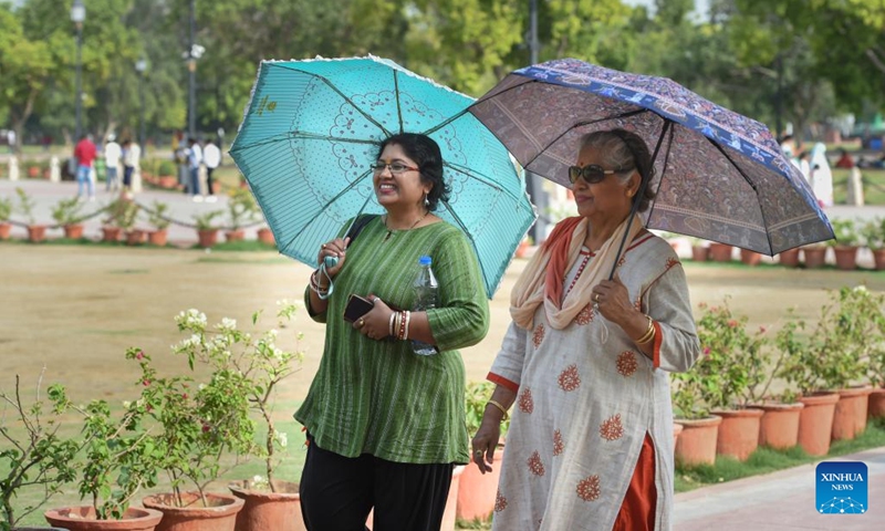 Women carry umbrellas during a hot summer day in New Delhi, India, May 15, 2023.(Photo: Xinhua)