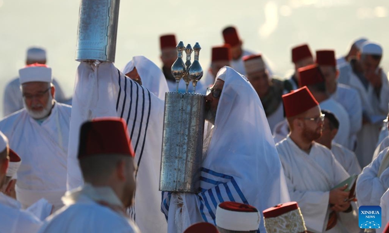 A priest of the Samaritan community holds up Torah scroll during the pilgrimage for the holy day of Passover on the top of Mount Gerizim, near the West Bank city of Nablus, May 10, 2023.(Photo: Xinhua)