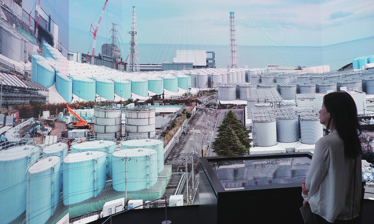 A Global Times reporter watches a video of the storage tanks of nuclear-contaminated wastewater at the Fukushima Daiichi Nuclear Power Plant at the TEPCO Decommissioning Archive Center on May 10, 2023. Photo: Xu Keyue/GT