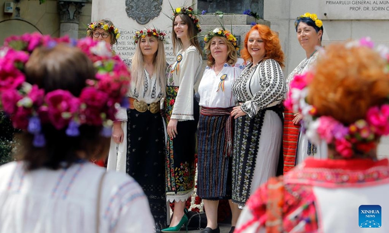 Women pose for photos during an event showcasing Romania's traditional costumes in downtown Bucharest, capital of Romania, May 14, 2023.(Photo: Xinhua)