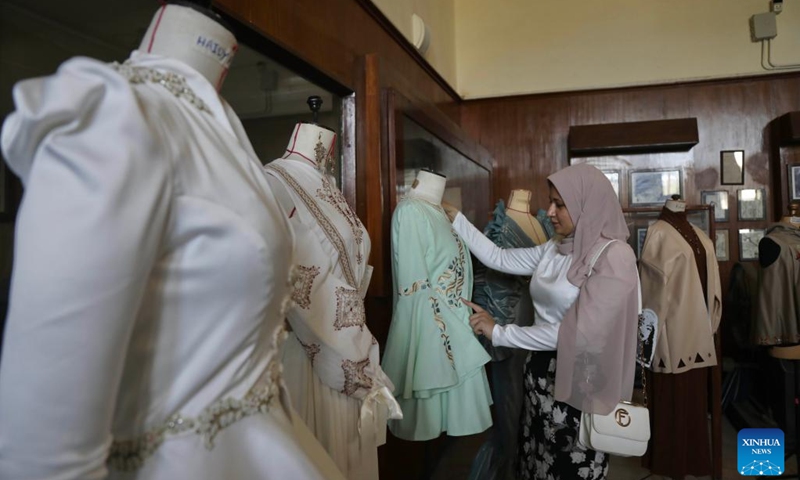 A woman visits an exhibition of clothes and accessories during the first edition of the Egypt Fashion Week in Cairo, Egypt, May 13, 2023. More than 70 Egyptian designers showcased their collections on and off the runway in the first edition of the Egypt Fashion Week, a four-day event that began on Friday.(Photo: Xinhua)