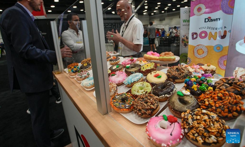 Different donut creations are displayed at a booth during the Bakery Showcase 2023 held at the Vancouver Convention Centre in Vancouver, British Columbia, Canada, on May 14, 2023.(Photo: Xinhua)