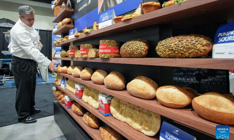 An exhibitor shows different types of bread during the Bakery Showcase 2023 held at the Vancouver Convention Centre in Vancouver, British Columbia, Canada, on May 14, 2023.(Photo: Xinhua)