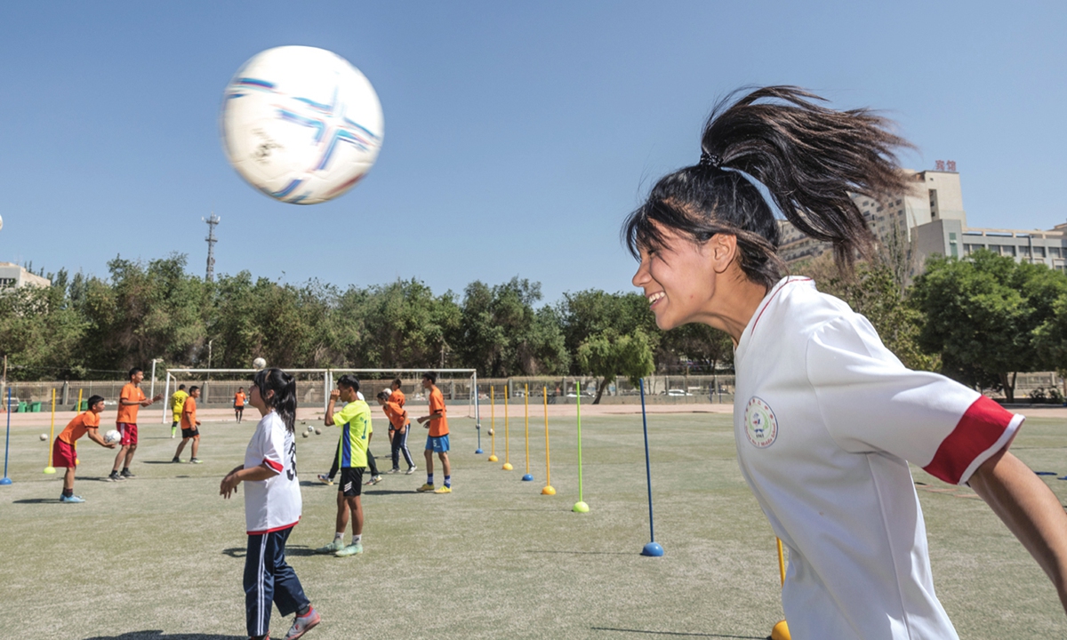 A girl (right) gives the ball a header during a training session at the Shache County No. 2 Middle School on May 15, 2023.