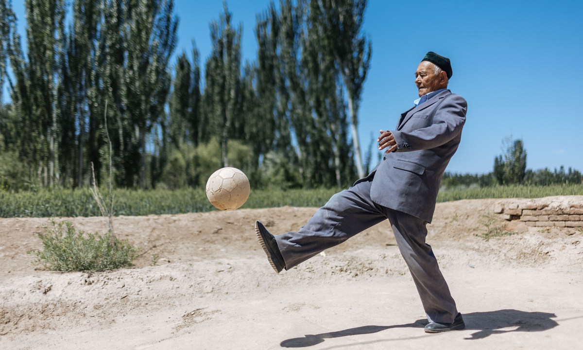Jurat, 88, showcases his soccer skills near a wheat field at Yikesake village on May 16, 2023.