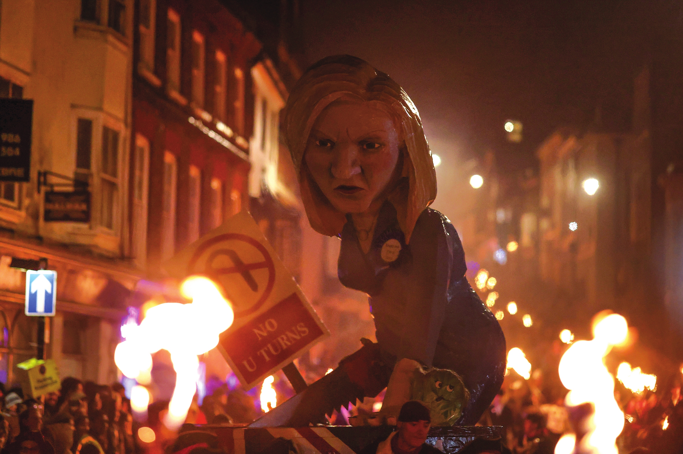People walk with an effigy of Liz Truss with a 