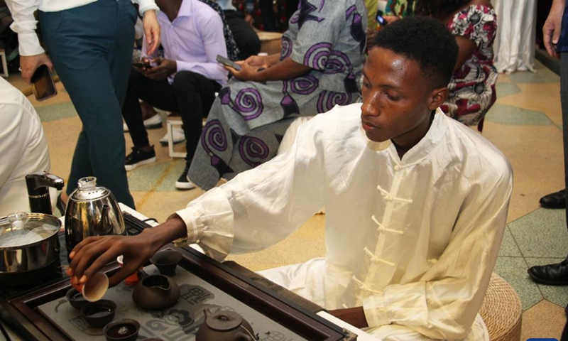 A student from the Confucius Institute prepares cups of tea at a tea-themed cultural event in Cotonou, Benin, May 20, 2023. A tea-promoting event was held in Cotonou of Benin on Saturday. Various event was held including tea tasting, tea ceremony performance, and Taij performance. The International Tea Day is observed every year on May 21. (Photo by Seraphin Zounyekpe/Xinhua)