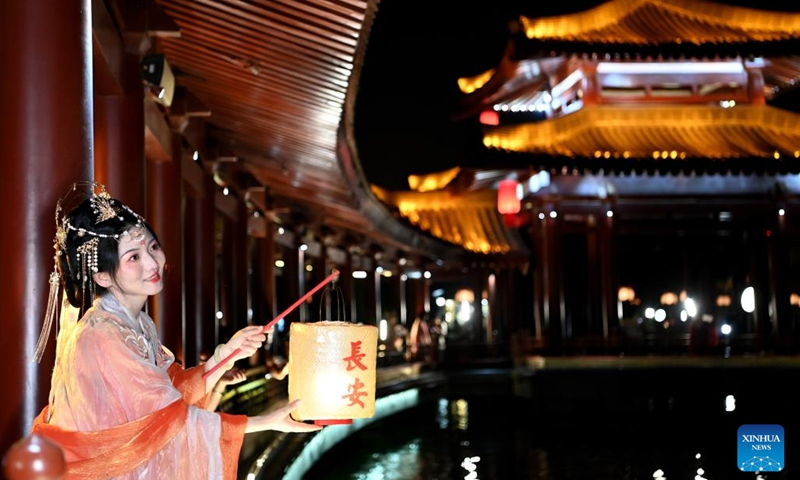 A tourist poses for photos at the Tang Paradise in Xi'an, northwest China's Shaanxi Province, April 19, 2023. The Tang Paradise, located in the south of Xi'an, is a large cultural theme park showing the life style of the prosperous Tang Dynasty (618-907).(Photo: Xinhua)