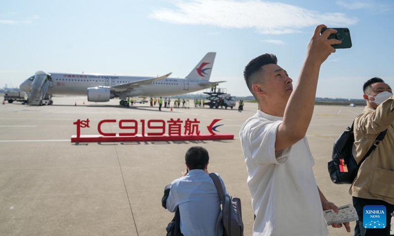 Passengers take photos with a C919, China's self-developed large passenger aircraft, before its first commercial flight in east China's Shanghai, May 28, 2023, C919 kicked off its first commercial flight from Shanghai to Beijing on Sunday, marking its official entry into the civil aviation market. (Xinhua)