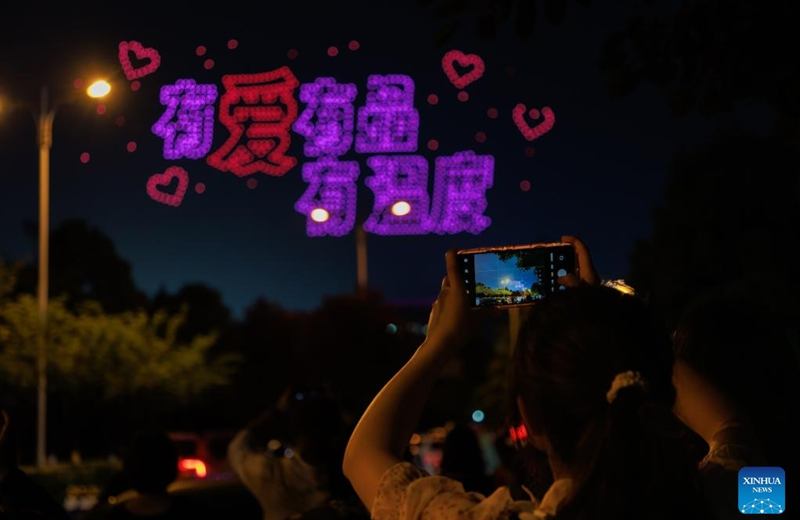 People take photos of a drone light show in Guiyang, southwest China's Guizhou Province, May 18, 2023. Altogether 1,000 drones performed a light show over Guiyang Thursday night. (Xinhua/Liu Xu)