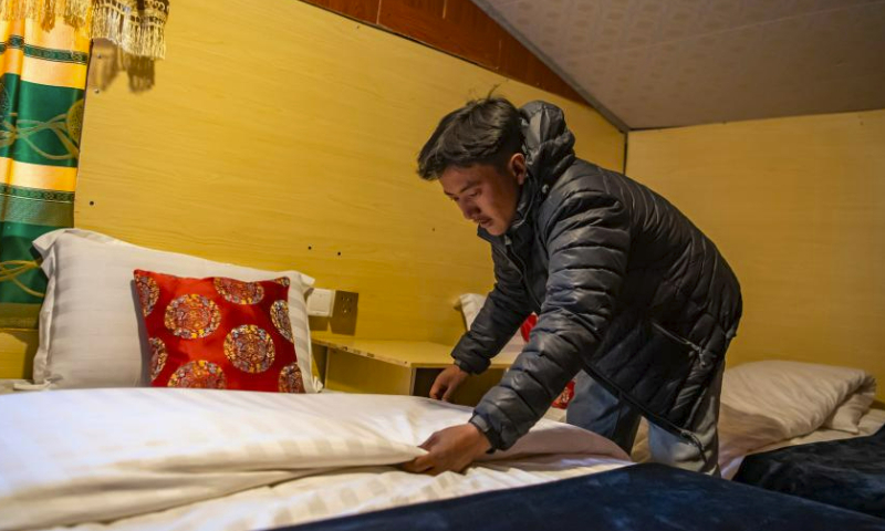 Dainzin makes the bed in a tent hotel at the Mount Qomolangma base camp for tourists in Zhaxizom Township of Tingri County in Xigaze City, southwest China's Tibet Autonomous Region, May 13, 2023.

The Mount Qomolangma base camp for tourists is dotted with tent hotels that accommodate travelers from afar. The tents are made from black yak fur, a unique scene at the mountain foot.

Dainzin, a 27-year-old local has been running a tent hotel at the base camp for nearly a decade. He is a witness to the booming tourism growth here.

Access to running water, electricity, emergency vehicles and oxygen facilities has been realized. Convenience store, sweet tea house and post office are also available.

Farmers and herdsmen in the township manage the tent hotels at the base camp, which are set up in March and open until October every year. (Xinhua/Sun Fei)