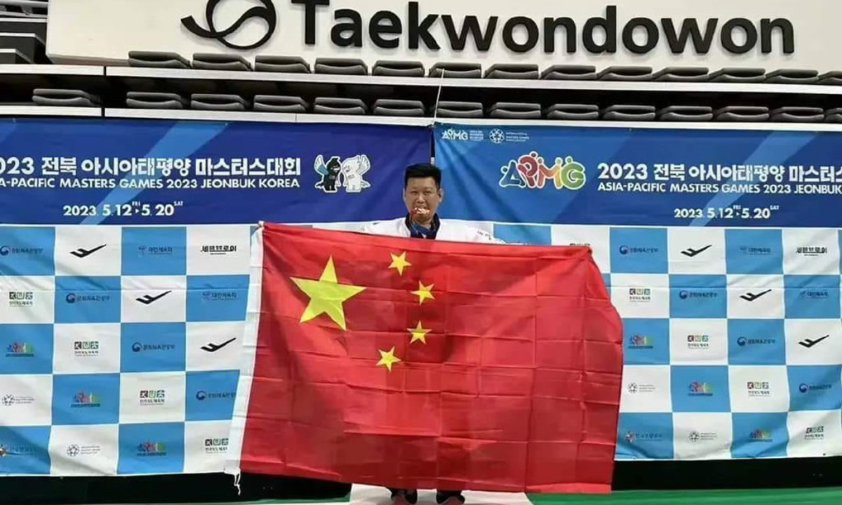 Taekwondo athlete Lee Tung-hsien from the Taiwan island of China holds a Chinese national flag after winning a bronze medal at the Asia-Pacific Masters Games in South Korea on May 14, 2023. Photo: Sina Weibo