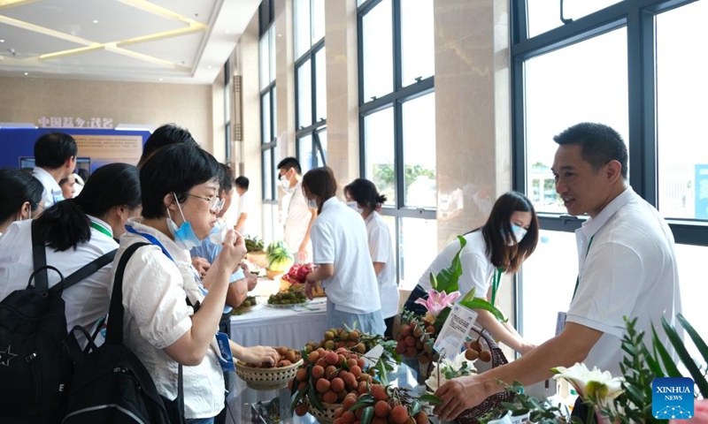 A visitor tastes a litchi during the China International Tropical Crops Industry Conference and the 7th China Litchi and Longan Industry Conference in Maoming, south China's Guangdong Province, May 20, 2023. The conference kicked off here on Saturday. (Xinhua/Xiong Jiayi)