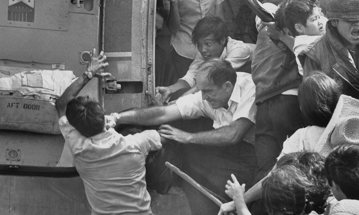 An American official punches a man in the face trying to pry him off the doorway of an airplane already overloaded with refugees seeking to flee Nha Trang, South Vietnam on April 2, 1975, according to The New York Times. Photo: VCG