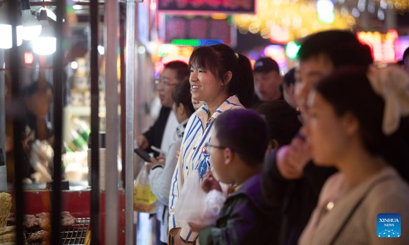 Tourists line up to buy snacks at a night market in Yichun, northeast China's Heilongjiang Province, May 19, 2023. The night market in Yichun has attracted a lot of tourists, which boosts its nighttime economy. (Xinhua/Zhang Tao)

