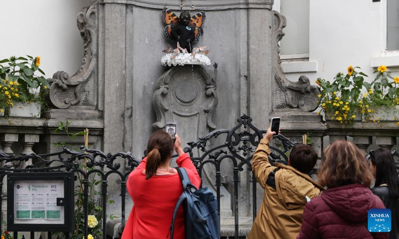 People take photos of the Manneken-Pis in Brussels, Belgium, May 22, 2023. Belgium's famous statue Manneken-Pis was decorated with a butterfly costume on Monday to celebrate the International Day for Biological Diversity.(Photo: Xinhua)