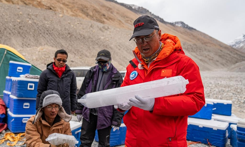 Kang Shichang (R), a researcher with the Northwest Institute of Eco-Environment and Resources under the Chinese Academy of Sciences (CAS), checks an ice core, drilled from Mount Qomolangma at an altitude of 6,500 meters, at the mountaineering base camp in the Qomolangma National Nature Reserve in southwest China's Tibet Autonomous Region, May 22, 2023.(Photo: Xinhua)
