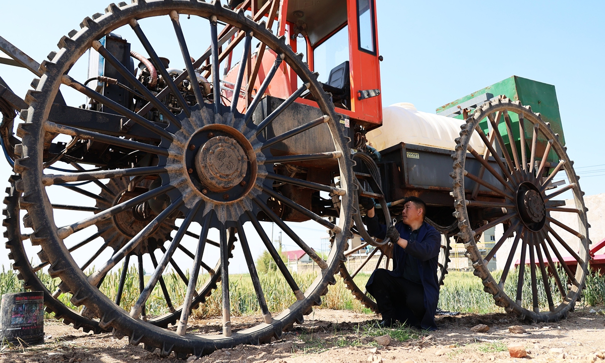 A farmer inspects agricultural machinery in Lianyungang, East China's Jiangsu Province on May 23, 2023. As one of the busiest farming seasons arrives, farmers are making preparations to ensure their harvests this year. Photo: cnsphoto