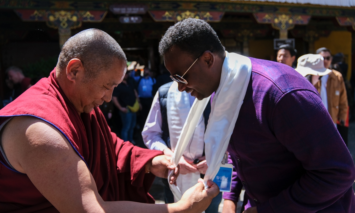A British guest receives a Khata from a Tibetan Buddhist on May 20, 2023 ahead of the 2023 Forum on the Development of Xizang, China. Guests from China and abroad were invited to visit the iconic Potala Palace and Jokhang Temple in Southwest China's Xizang Autonomo us Region ahead of the forum's opening. Photo: cnsphoto