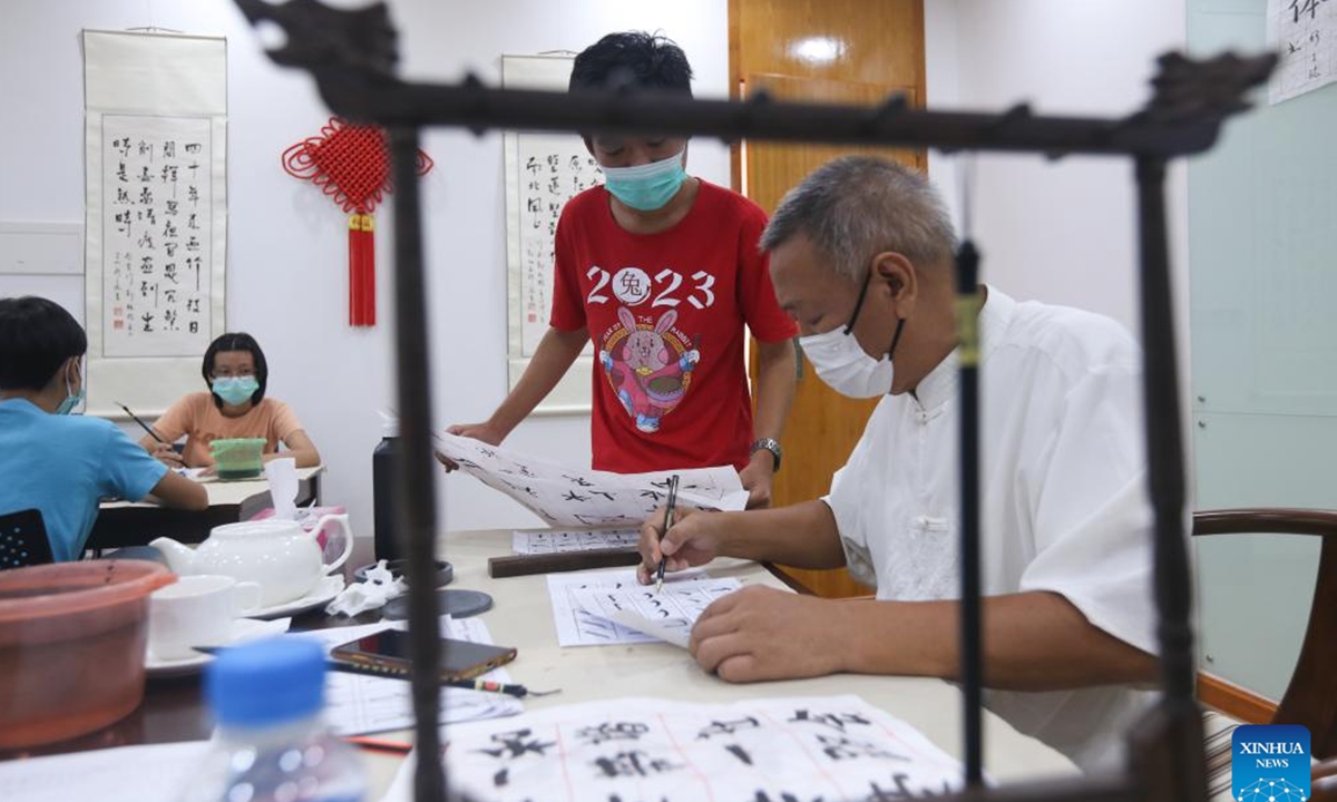 An instructor checks the students' calligraphy works at the China Cultural Center in Yangon, Myanmar, May 23, 2023. Some students in Myanmar have spent much of the summer vacation learning Chinese calligraphy at the China Cultural Center in Yangon.(Photo by Myo Kyaw Soe/Xinhua)






