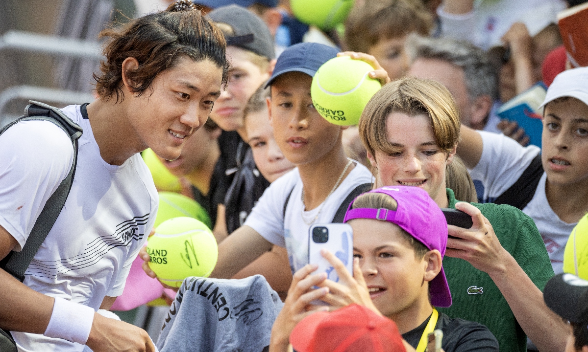 Zhang Zhizhen signs autographs and poses for photographs with fans at Roland Garros on May 27, 2023 in Paris, France. Photo: VCG