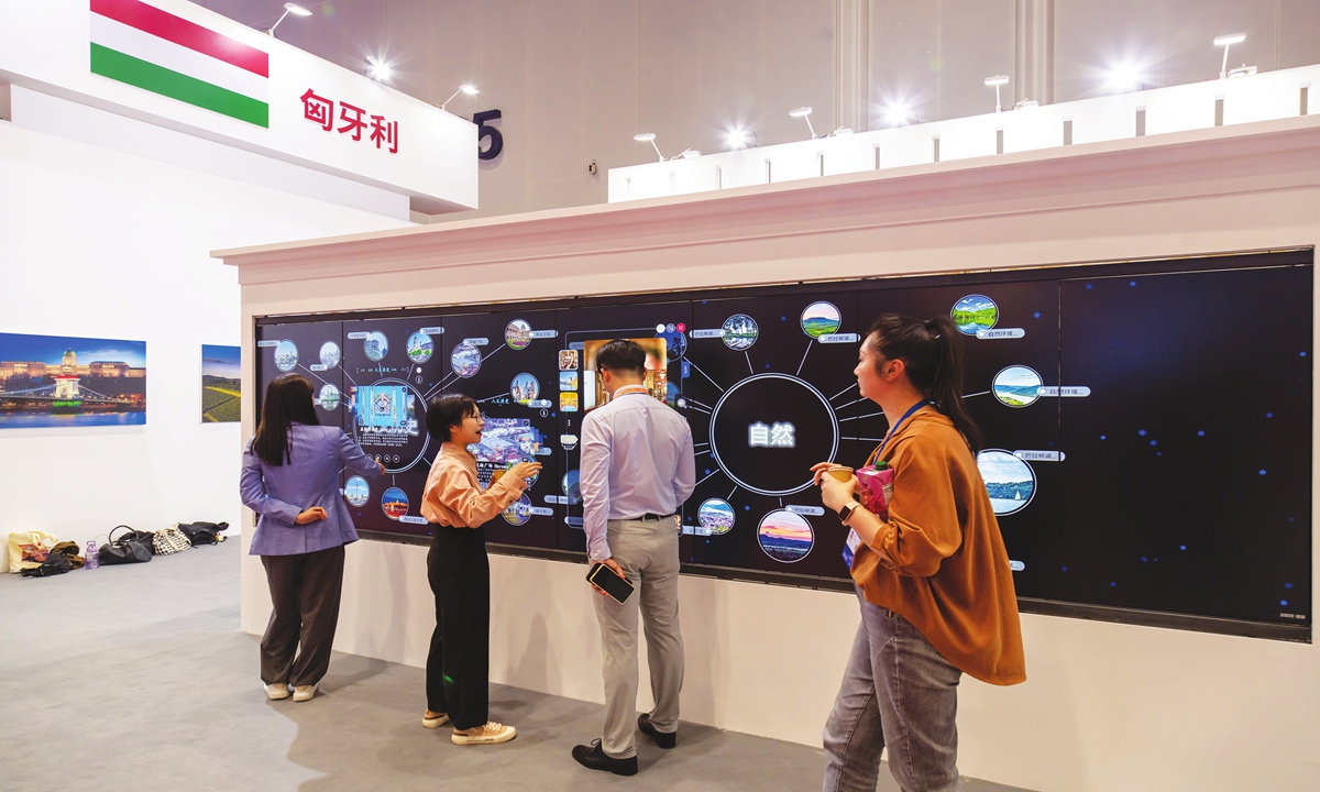 Visitors experience the magic wall and enjoy the Hungarian landscape through touch atthe Hungarian pavilion at the 3rd China-CEEC Expo in Ningbo, East China's Zhejiang Province,on May 16, 2023. Photo: VCG