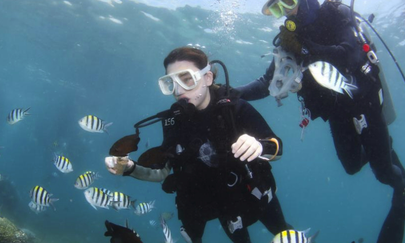 A tourist enjoy scuba diving in the waters of Fenjiezhou Island of Hainan Province, south China, May 27, 2023. (Xinhua/Yang Guanyu)