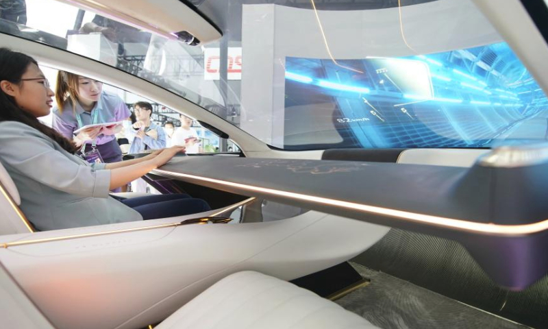 A staff member displays the HQ Intelligent System (HIS) at the exhibition area of Zhongguancun Forum in Beijing, capital of China, May 27, 2023. New energy vehicles and relevant products take the spotlight at this year's Zhongguancun Forum (ZGC Forum). (Xinhua/Zhang Chenlin)