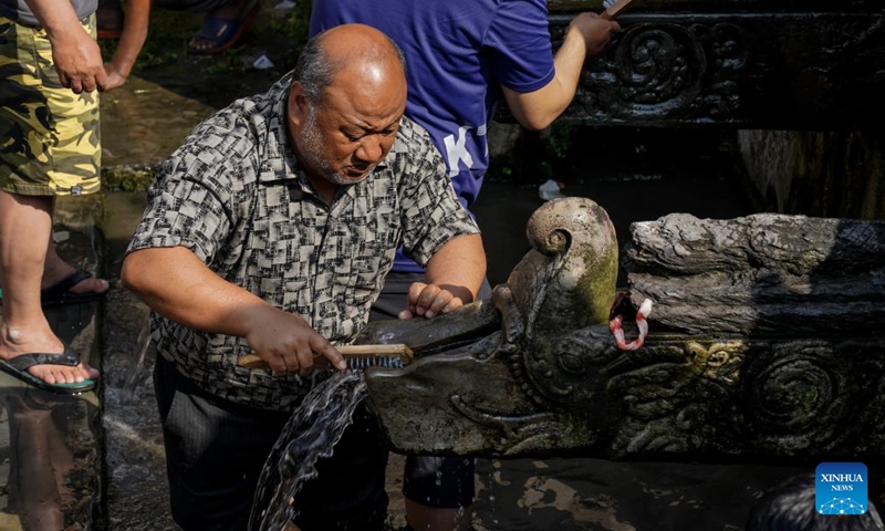 A man cleans a stone water spout on the occasion of Sithi Nakha Festival in Lalitpur, Nepal, May 25, 2023. The Newar community celebrates the Sithi Nakha festival to mark the beginning of monsoon season by cleaning water sources such as ponds, wells and stone spouts.(Photo: Xinhua)
