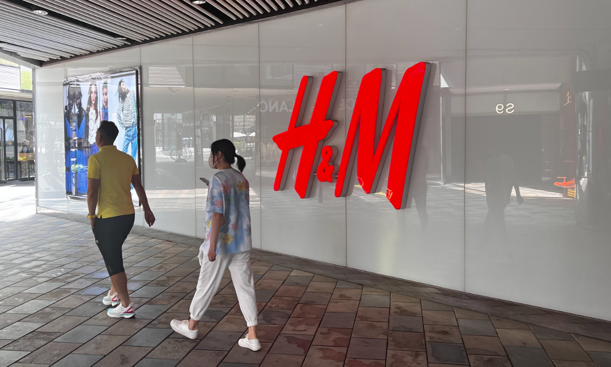 People walk pass the logo of H&M at its flagship store in Sanlitun, Beijing on May 29, 2023. Photo: Tao Mingyang/GT