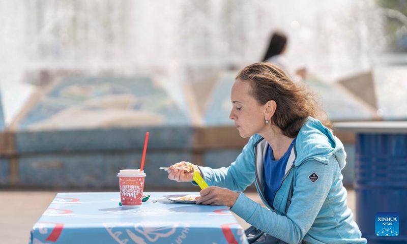 A woman enjoys food during a food festival in Vladivostok, Russia, May 25, 2023. Vladivostok, a city in the Russian Far East, organizes the Mega Taste Food Festival on Thursday.(Photo: Xinhua)