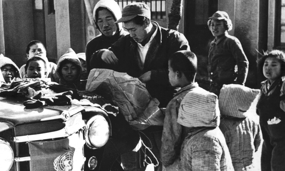 File photo: Korean War orphans gather around a United Nations jeep to examine the contents of parcels.