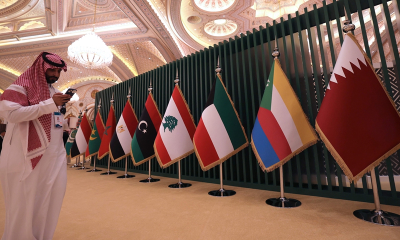 A man stands near national flags during the 10th Arab-China Business Conference in Riyadh, on June 11, 2023. Photo: VCG