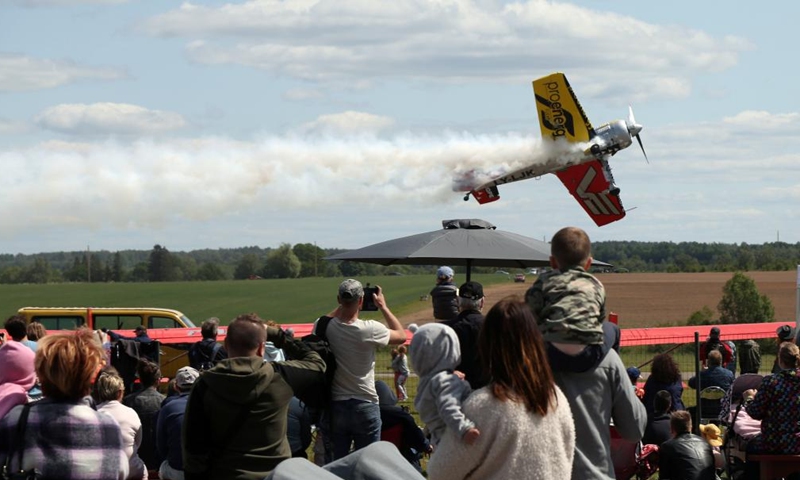 People watch an aircraft performing during the Fly in Limbazi air show in Limbazi, Latvia, on June 10, 2023. (Photo by Edijs Palens/Xinhua)