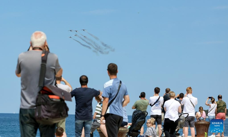 People watch a performance of the Croatian Air Force aerobatic team, Wings of Storm, in Zadar, Croatia, May 29, 2023. An aerobatic flight show was held here Monday to celebrate the Day of the Armed Forces of Croatia on May 28 and the Statehood Day on May 30.(Photo: Xinhua)