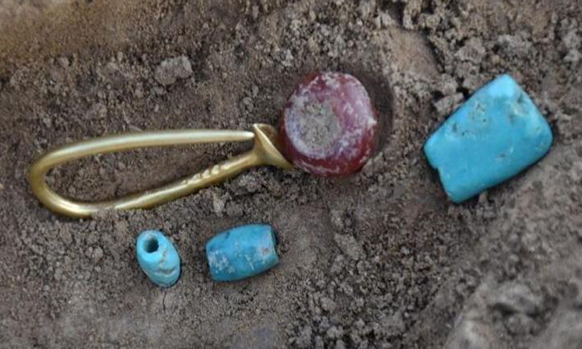 A flared gold earring along with turquoise and red agate beads from a high-level tomb discovered in Xingong site in Beijing's Fengtai district Photo: Courtesy of National Cultural Heritage Administration 