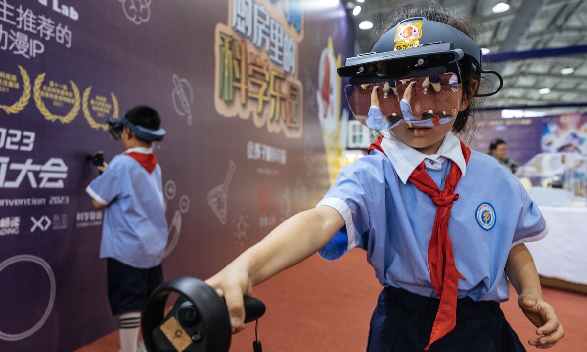 Students experience the latest cutting-edge technology in an immersive way at the China Science Fiction Convention 2023, which is held in Beijing from May 29 to June 4.  
Photo: Li Hao/GT