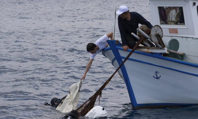 Divers and fishermen in collaboration with Enaleia, a local social start-up that runs projects of cleaning up seas and recycling and upcycling plastic waste into new products, collect ghost nets and plastic packages from the Saronic Gulf around Salamis island, next to Athens, Greece, May 26, 2023. The World Environment Day 2023 will focus on beating plastic pollution and spotlight solutions to plastic pollution. (Photo by Lefteris Partsalis/Xinhua)