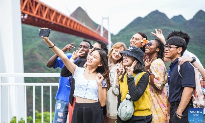 International students take a selfie while visiting the Baling River bridge in southwest China's Guizhou Province, June 3, 2023. A total of 40 international students from 24 countries have recently attended a culture promotion activity to learn about Guizhou Province, especially its achievements in transport infrastructure construction and rural revitalization. (Xinhua/Tao Liang)