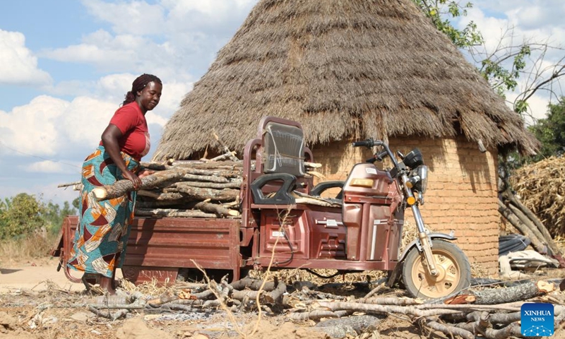 Philis Chifamba offloads firewood from an e-tricycle at her home in Wedza, about 140 kilometres from Zimbabwe's capital Harare on May 19, 2023.(Photo: Xinhua)