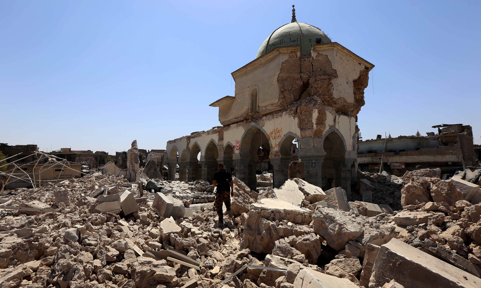 A member of Iraq's Counter-Terrorism Service (CTS) walks past part of the destroyed Al-Nuri Mosque in Mosul's old city on July 30, 2017. Photo: VCG